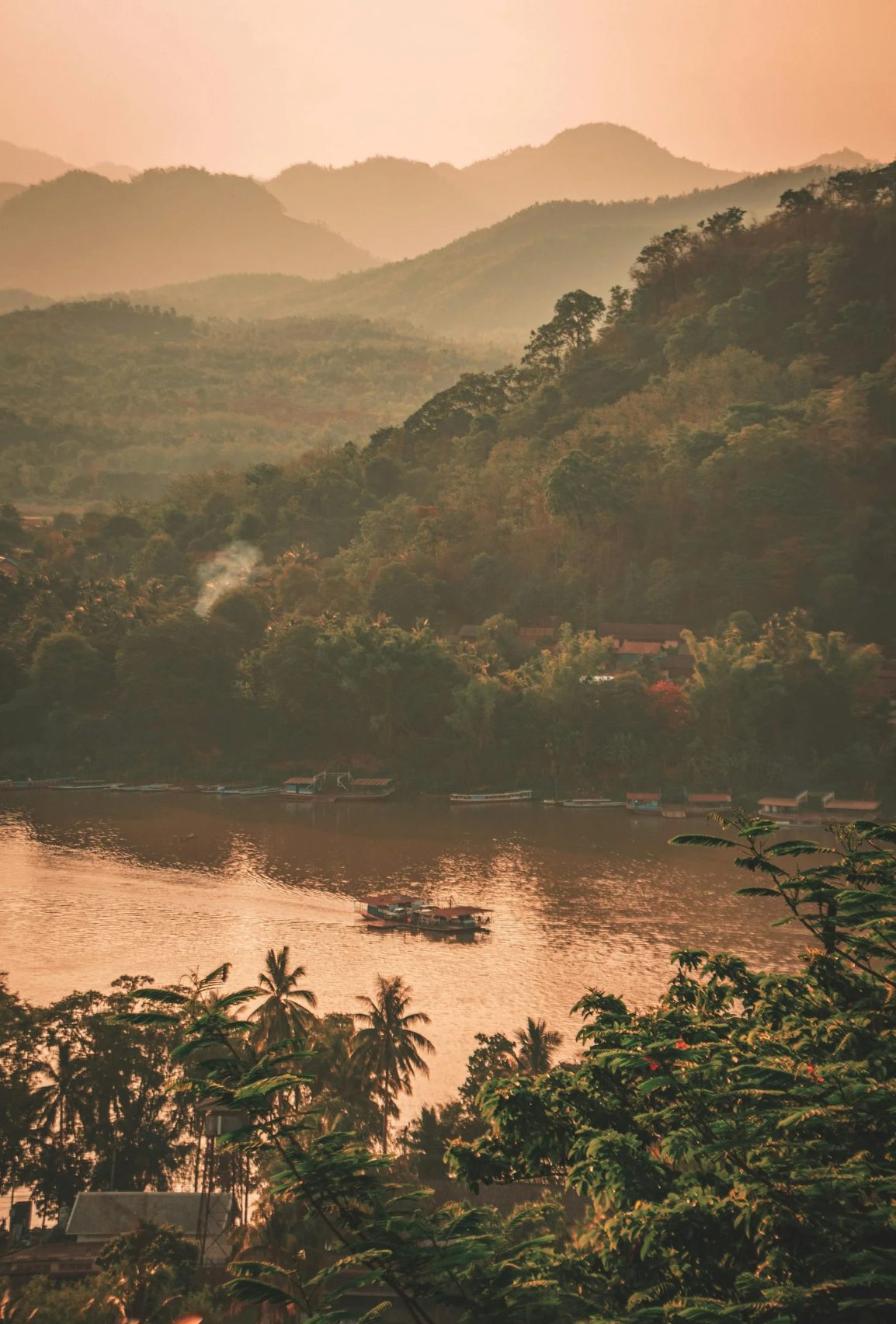 Sunset over the Mekong river with lush jungle mountains in Luang Prabang Laos, home of Opus Distillery